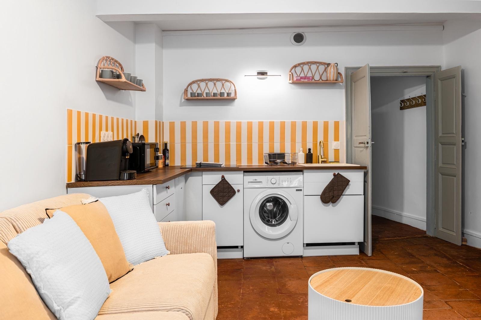 Coin cuisine ouvert sur le salon avec crédence rayée jaune