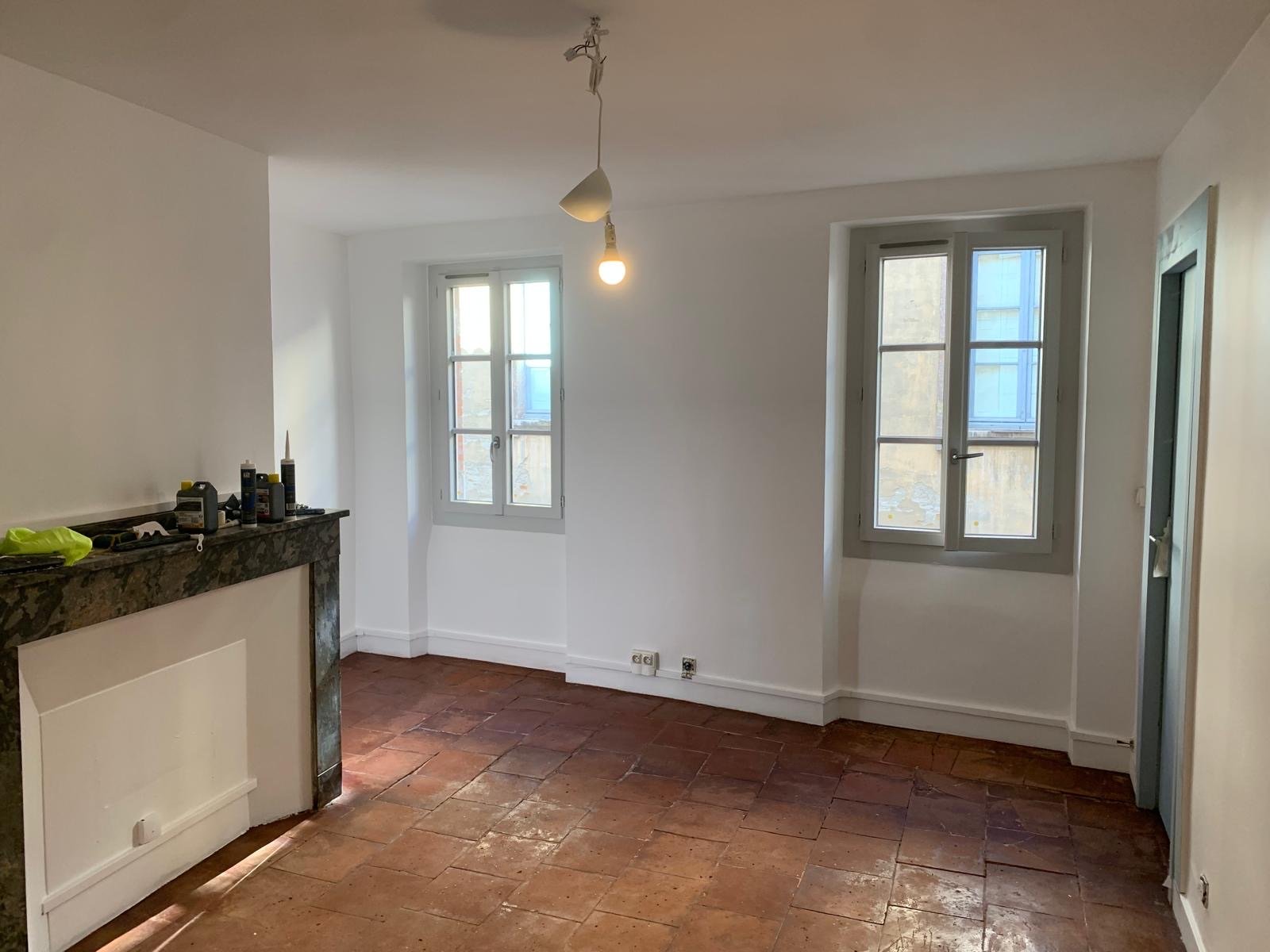 Séjour à l'état brut avant rénovation, avec cheminée en marbre