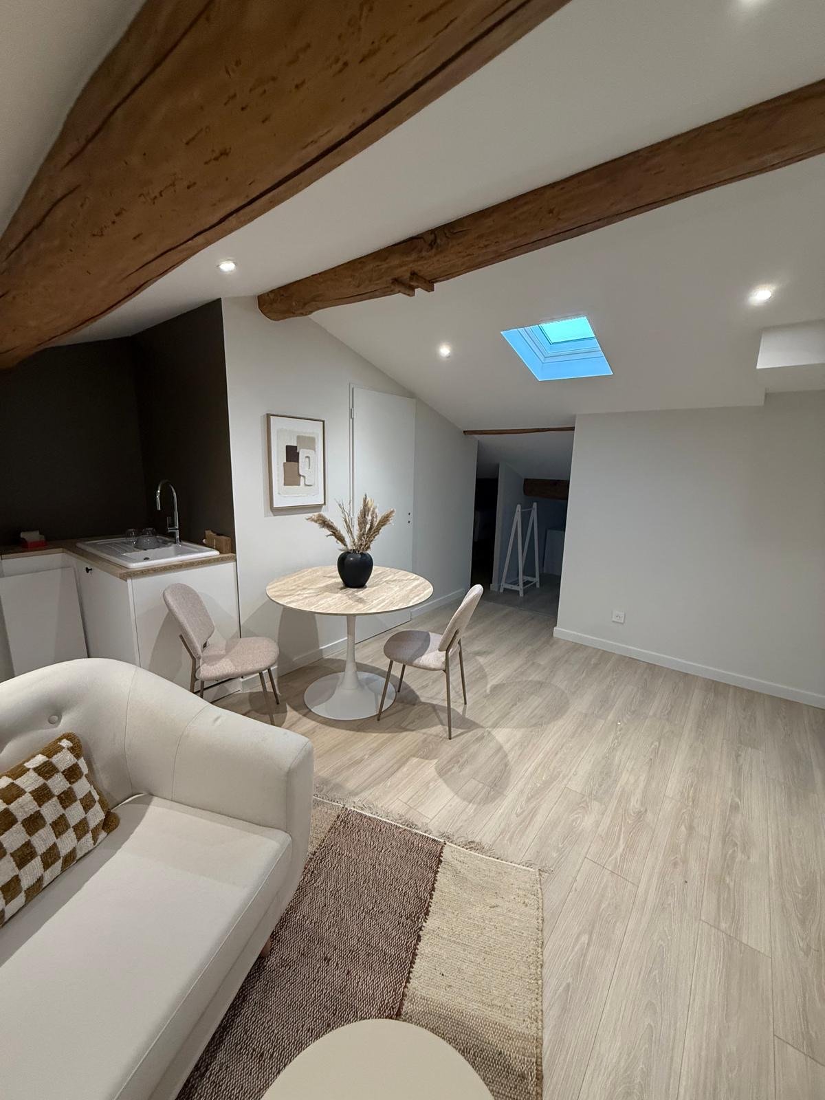 Séjour avec poutre apparente et kitchenette